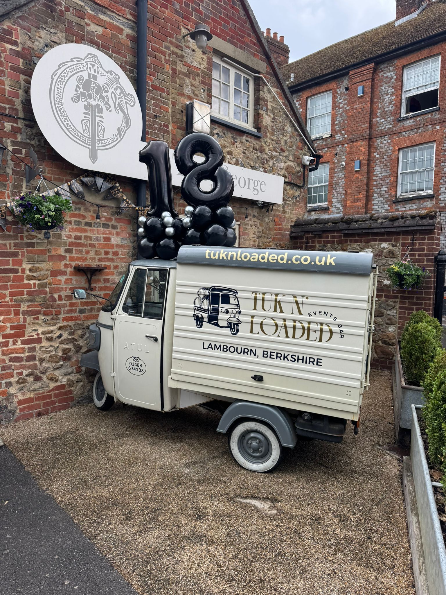 Side view of the Tuk N' Loaded tuktuk showing its branding outside the pub